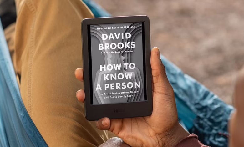 Person relaxing in a hammock reads David Brooks's "How to Know a Person" on a Kindle.