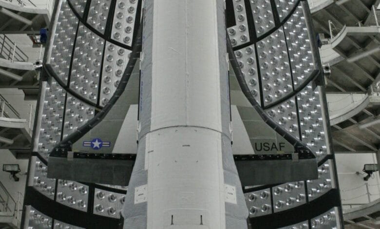 Close-up view of a spacecraft's heat shield, showing numerous small, circular vents and the USAF insignia.