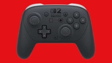 A dark gray Nintendo Switch Pro controller with white accents against a red background.