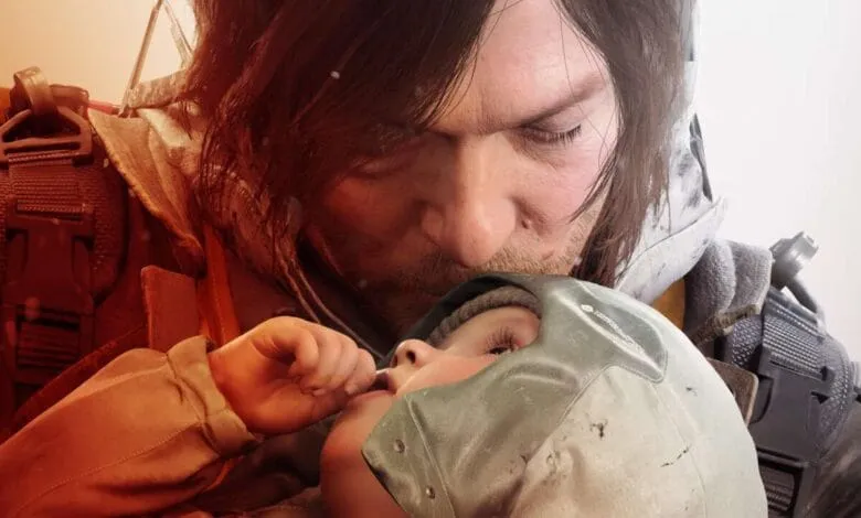 A man gently kisses a baby wearing protective headgear; both appear weathered and the scene is set against a snowy, muted background.