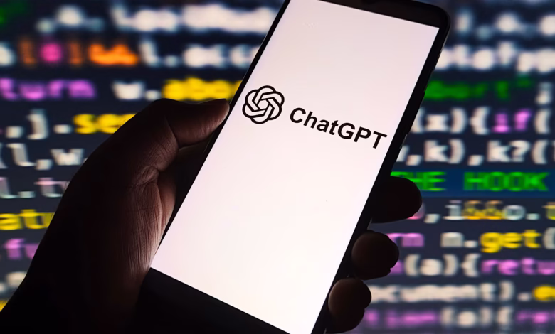 Close-up of a smartphone displaying the ChatGPT logo against a blurred background of colorful computer code.