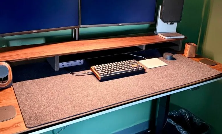 Modern ergonomic workstation with dual Dell monitors, wooden desk, mechanical keyboard, and mousepad.