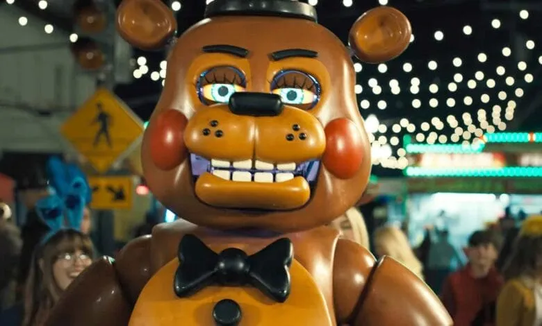 A large animatronic Freddy Fazbear from Five Nights at Freddy's walks through a nighttime festival.