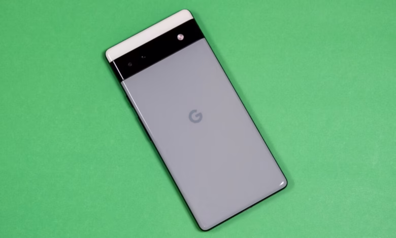 Google Pixel phone's rear view, showcasing its light gray back, black camera bar, and Google logo. The phone rests on a green background.