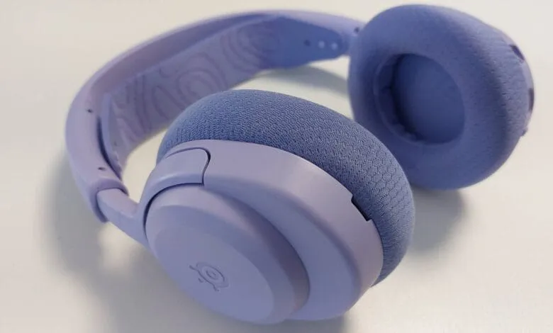Pair of lavender-colored headphones with soft earcups, resting on a white surface.