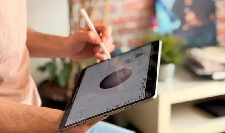 Person using a stylus on a tablet to draw a circle. The tablet displays a digital sketch.