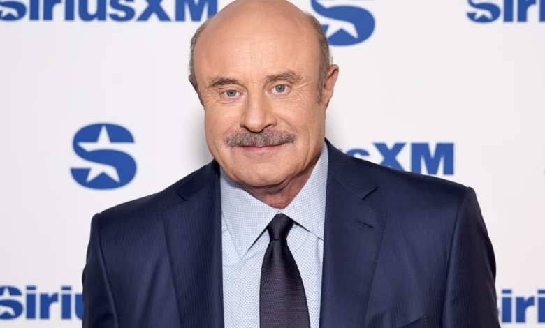Dr. Phil McGraw, a television personality, smiles in a navy suit against a SiriusXM backdrop.