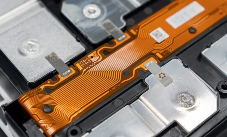 Close-up of an electric vehicle's lithium iron phosphate (LFP) battery cell, showcasing intricate wire connections and modular design.