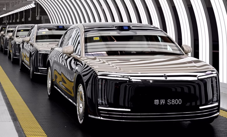 A line of luxury Hongqi S800 cars moves along an assembly line in a modern factory.