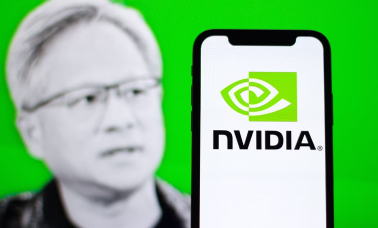 Nvidia logo displayed on a smartphone with Jensen Huang, CEO of Nvidia, blurred in the background.