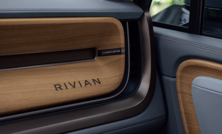 Close-up of a Rivian car's interior, showcasing a wood and dark gray dashboard with the Rivian logo and 'Launch Edition' label.