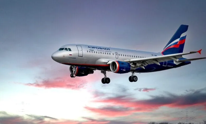 Aeroflot Airbus A319 approaching landing, against a sunset sky.