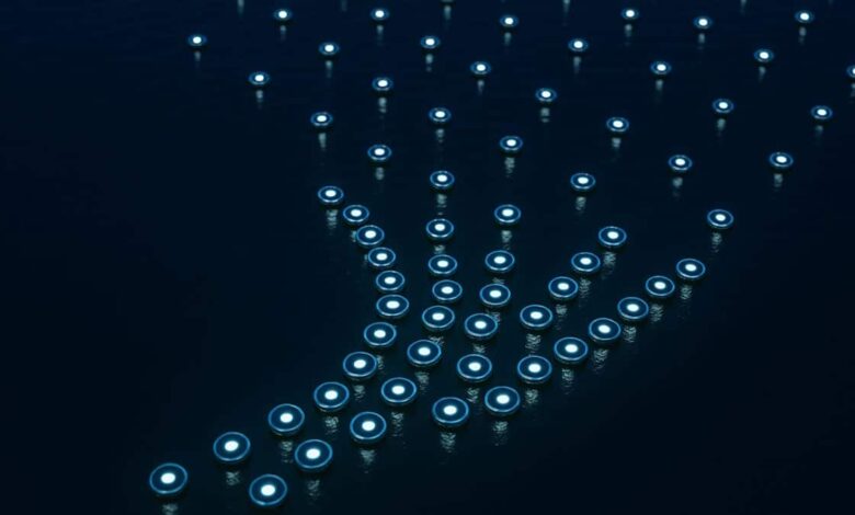 Numerous small, glowing discs arranged in the shape of a hand on a dark surface.