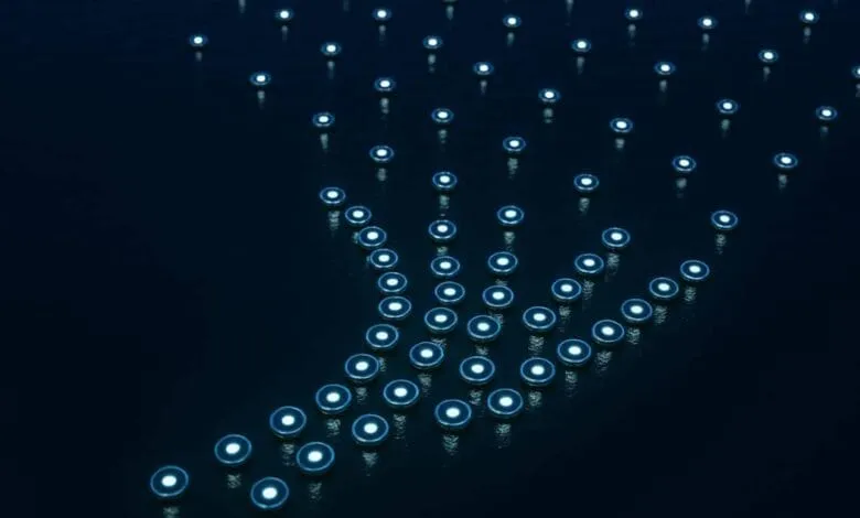 Numerous small, glowing discs arranged in the shape of a hand on a dark surface.