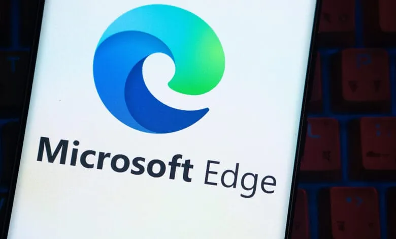 Microsoft Edge logo displayed on a smartphone screen, partially visible against a blurred keyboard.