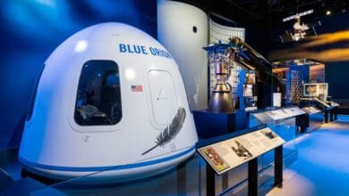 Blue Origin's New Shepard space capsule and rocket engine displayed in a museum exhibit, showcasing space exploration technology.