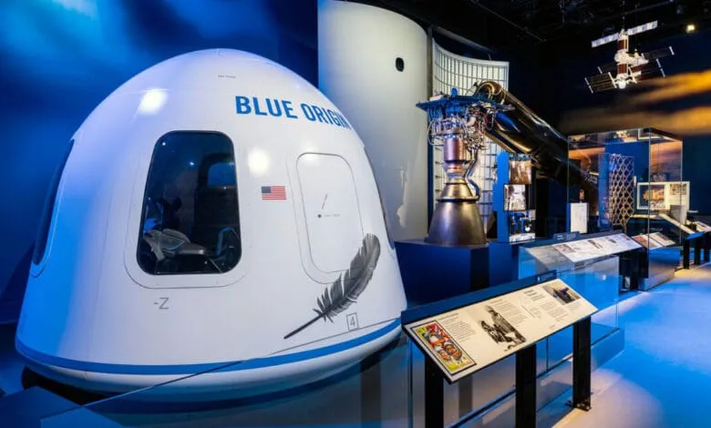 Blue Origin's New Shepard space capsule and rocket engine displayed in a museum exhibit, showcasing space exploration technology.