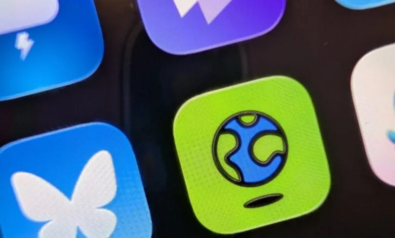 Close-up of a smartphone screen displaying app icons, one prominently featuring a blue globe on a lime green square.