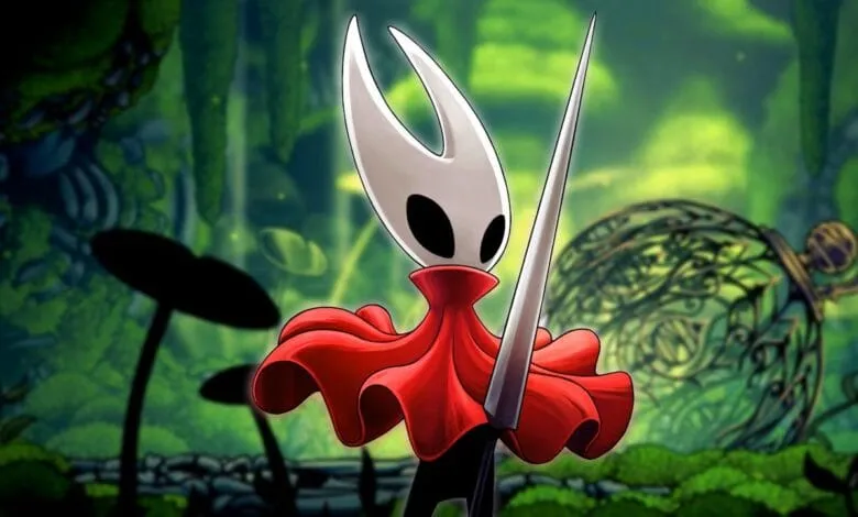 Hornet, from Hollow Knight: Silksong, stands in a lush forest, holding her needle weapon. She wears a red cloak.