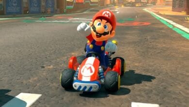Mario, the iconic video game character, smiles while driving his red kart on a race track.