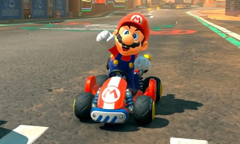 Mario, the iconic video game character, smiles while driving his red kart on a race track.