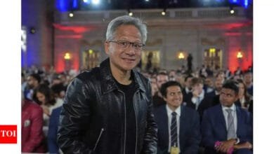 Jack Ma, founder of Alibaba, smiles at a large event, wearing a black leather jacket.