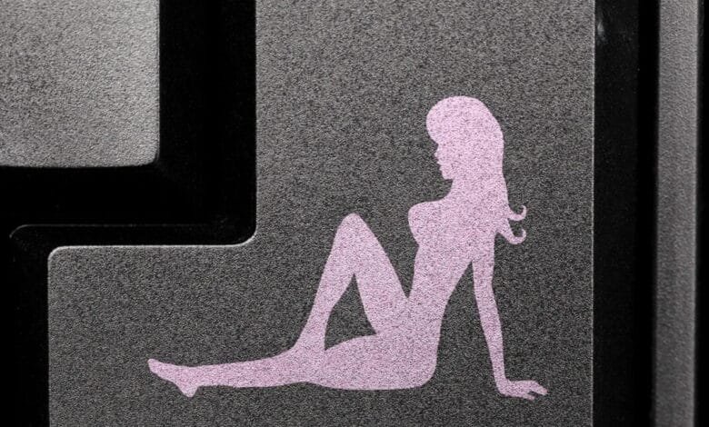Close-up of a keyboard key featuring a pink silhouette of a woman reclining.