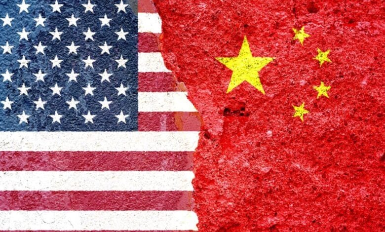 US and Chinese flags painted on a cracked wall, symbolizing strained relations.