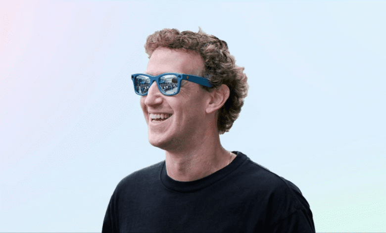 Mark Zuckerberg, Meta CEO, smiles while wearing blue sunglasses against a soft pastel background.