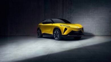 Sleek yellow electric SUV concept car in a dark industrial setting, showcasing its modern design and sharp lines.