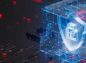 Cybersecurity concept: glowing blue shield within a digital cube on a dark tech background.