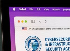 Close-up of a laptop screen displaying the Cybersecurity and Infrastructure Security Agency (CISA) website on Safari.