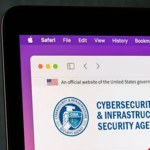 Close-up of a laptop screen displaying the Cybersecurity and Infrastructure Security Agency (CISA) website on Safari.
