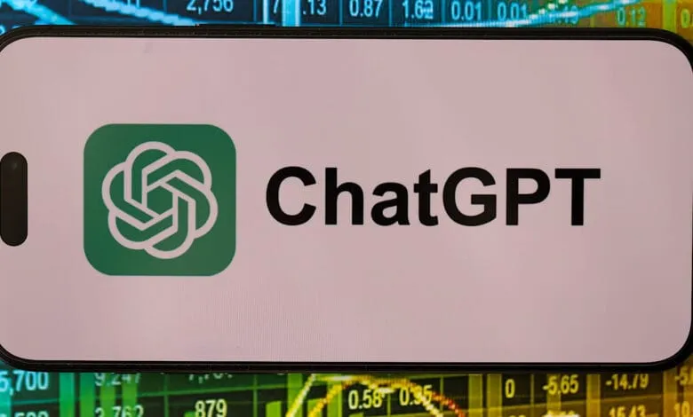 Close-up of a smartphone displaying the ChatGPT logo against a blurred background of stock market data.