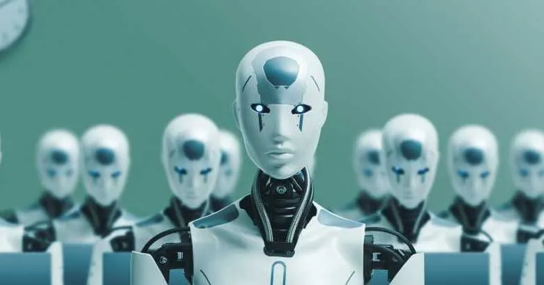 A row of humanoid robots sits at desks in an office, one robot in the foreground looking directly at the viewer.