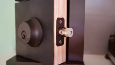 Close-up of a dark brown door lock with a silver latch, showing keyhole and detail.