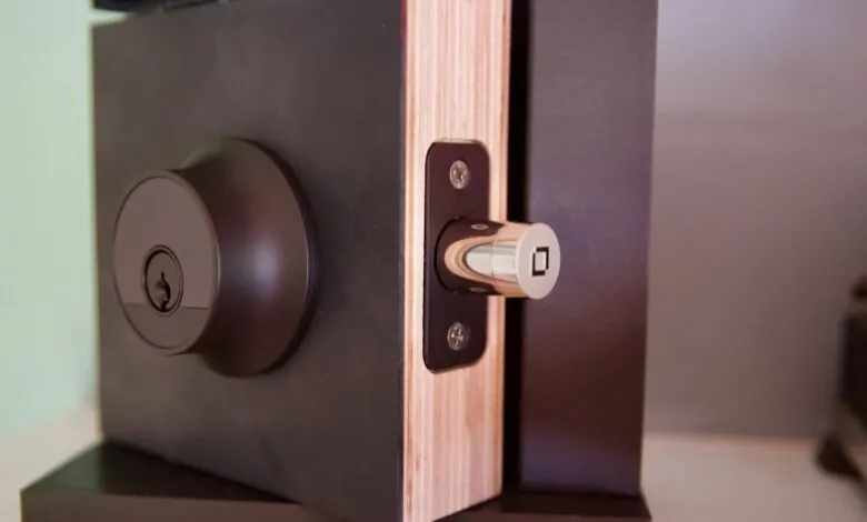 Close-up of a dark brown door lock with a silver latch, showing keyhole and detail.