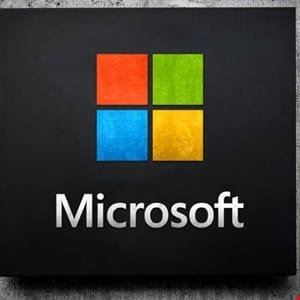 Microsoft logo on a dark background. Four colored squares form the iconic Windows logo.