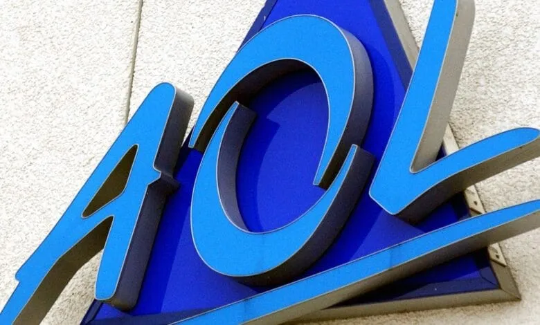 Close-up of a blue and silver AOL logo mounted on a white wall.