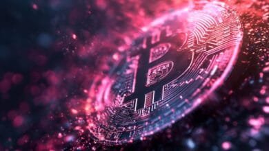 Close-up of a Bitcoin cryptocurrency coin, glowing with pink and red light, surrounded by digital particles.