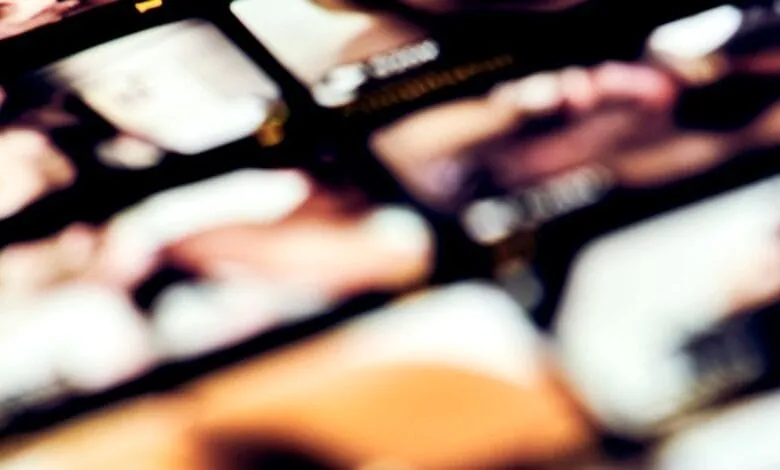 Blurred grid of warm-toned abstract shapes and textures.