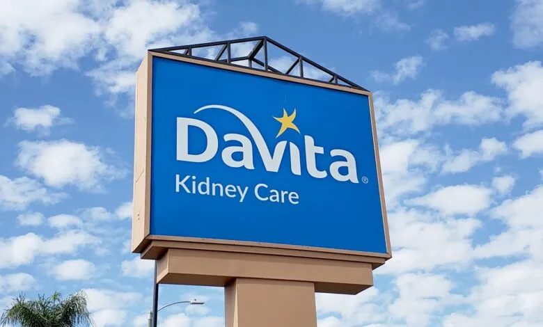 DaVita Kidney Care sign against a bright blue sky with fluffy white clouds.
