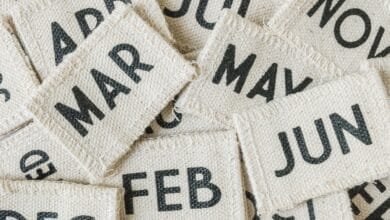 Close-up of fabric squares with months of the year printed on them, overlapping and creating a textured background.