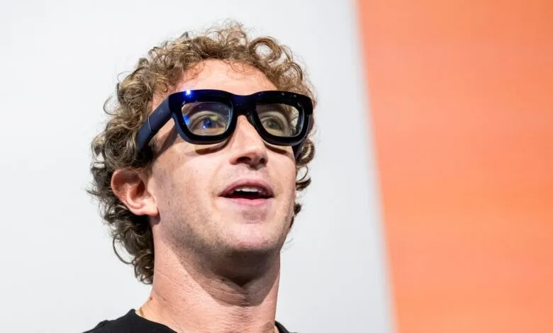 Close-up of Mark Zuckerberg wearing black-framed glasses, looking upward.