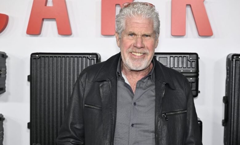 Actor Danny Trejo smiles at a premiere event, wearing a black leather jacket.