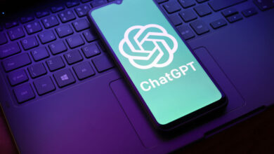 ChatGPT logo displayed on a smartphone screen resting on a laptop keyboard.