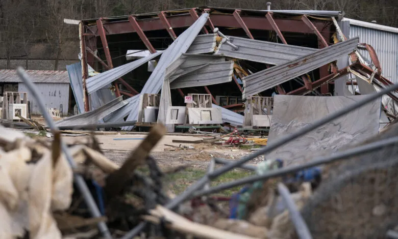 Damaged building after Hurricane Helene in Asheville, NC. Twisted metal and debris surround the structure.