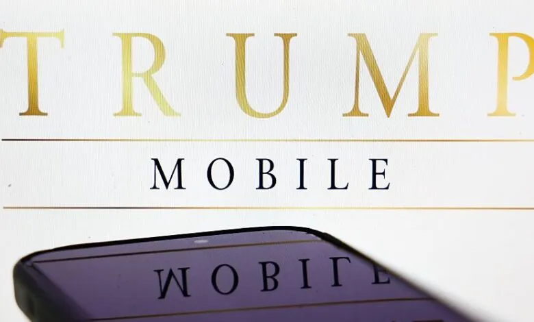 Close-up of a smartphone reflecting the words 'TRUMP MOBILE' in gold lettering.