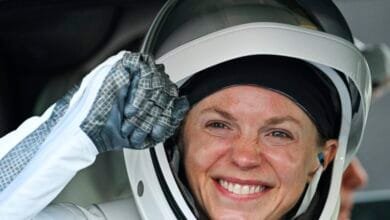 Smiling astronaut Zena Cardman in spacesuit, preparing for launch.