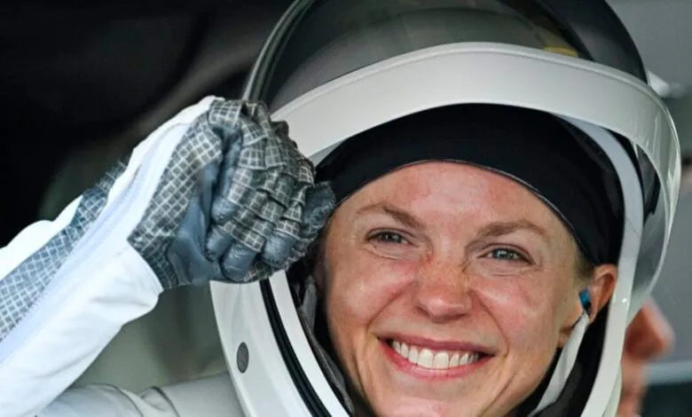 Smiling astronaut Zena Cardman in spacesuit, preparing for launch.